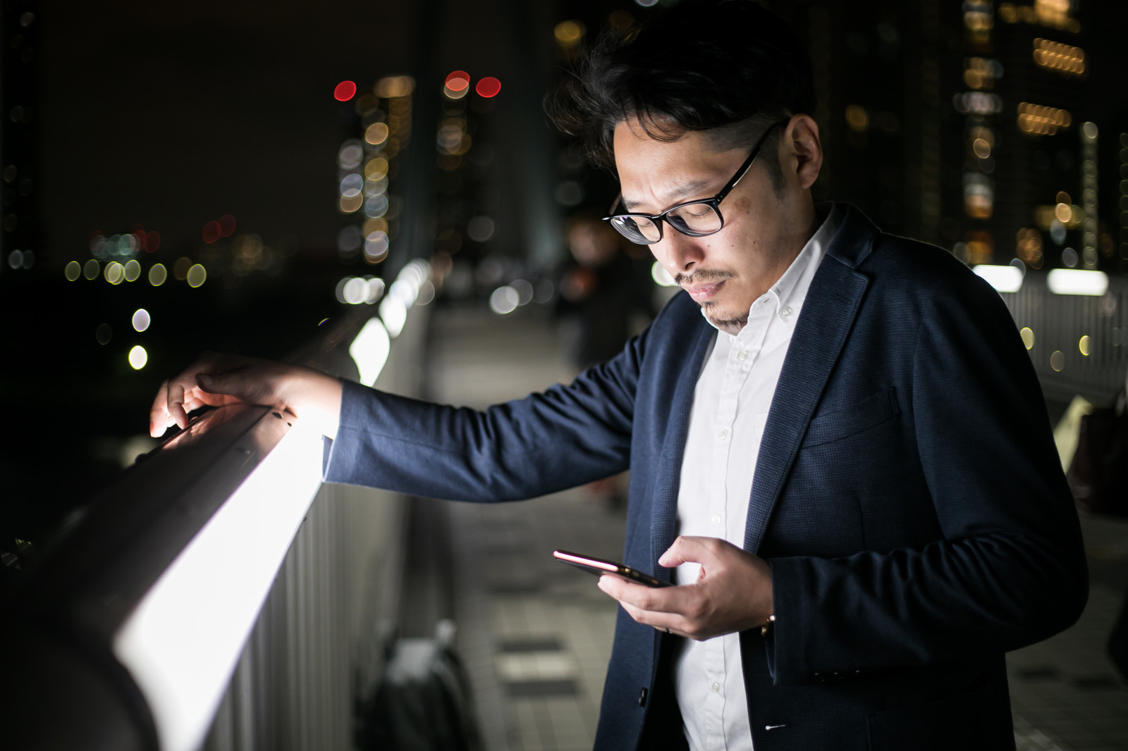 屋外でスマホを見つめる男