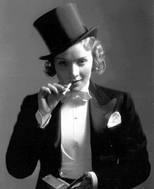 煙草をくわえ不敵に笑う女性