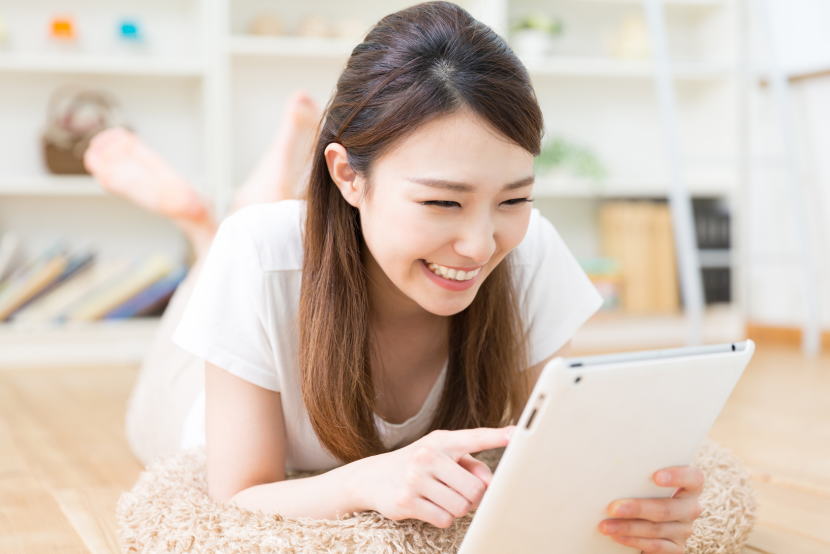 タブレットを見て笑う女性
